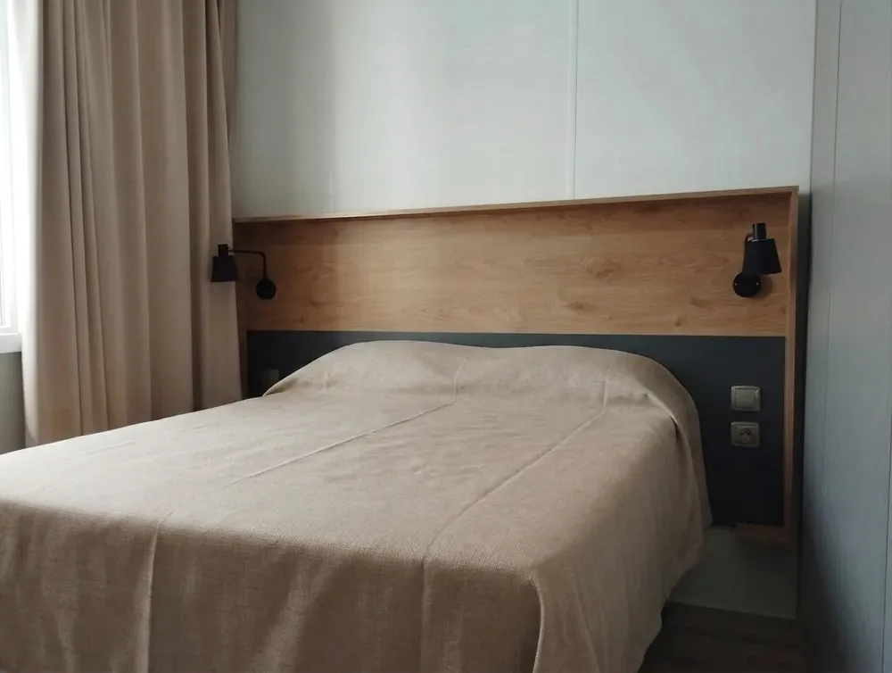 Modern mobile home bedroom with double bed and black-and-wood bicolor headboard