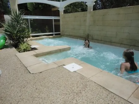 Outdoor whirlpool bath with bubbling water and relaxing users