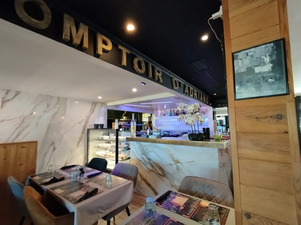 Comptoir moderne en marbre blanc d'un restaurant de camping avec éclairage soigné et tables dressées