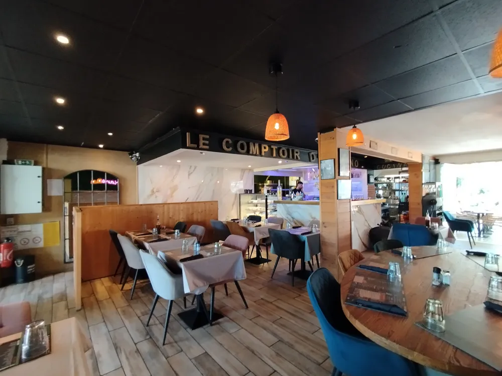 Intérieur lumineux d'un restaurant de camping avec vue sur les tables dressées et le bar